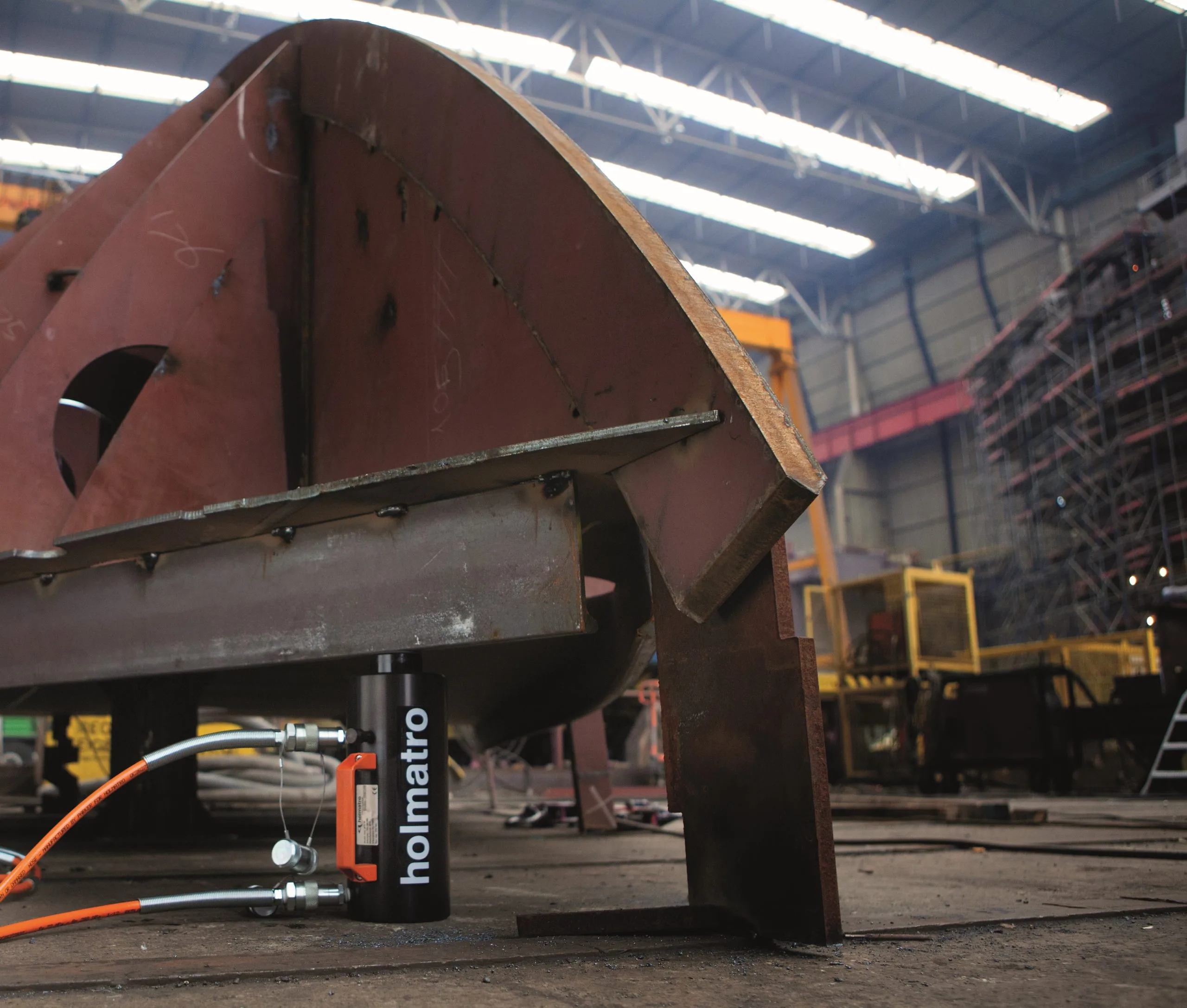 Holmatro-Hydraulikzylinder beim Abstützen eines Stahlbauteils in einer Werfthalle